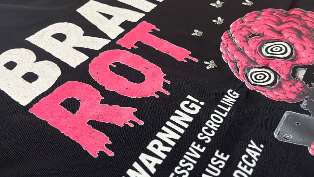Brain Rot pink and white print on a black tee